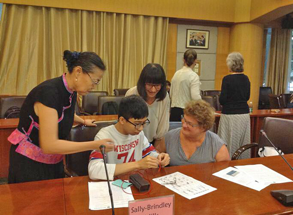 周健教授(左一)指导艺术设计专业学生(左二)教访问团老师Carol做中国结,右二为英语专业学生翻译 周健教授(左一)指导艺术设计专业学生(左二)教访问团老师Carol做中国结,右二为英语专业学生翻译